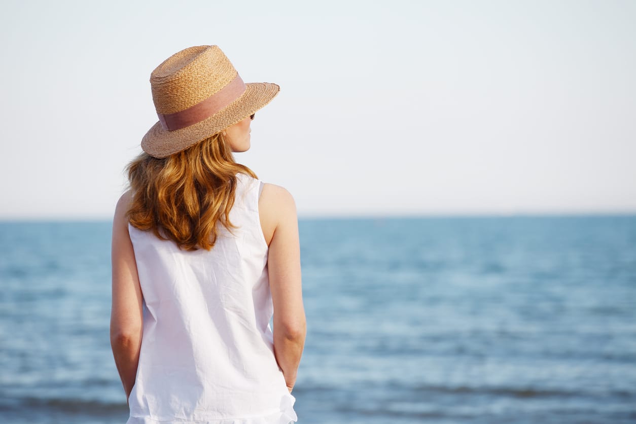 Woman wearing a sun hat by the ocean