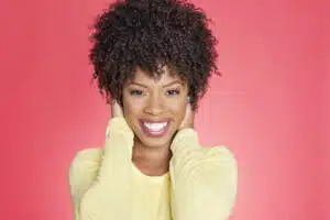 Portrait of a cheerful African American woman with hands over ears