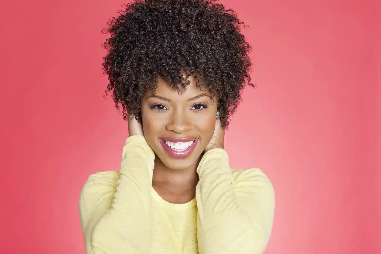 Portrait of a cheerful African American woman with hands over ears