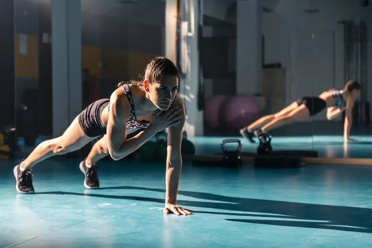 Exercises for a smaller waist woman doing plank shoulder taps