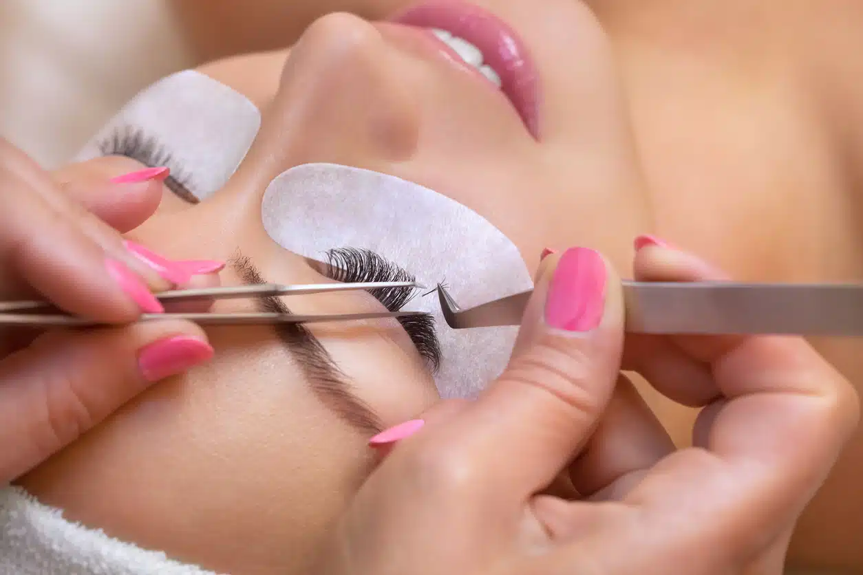 Salon technician applying false eyelashes