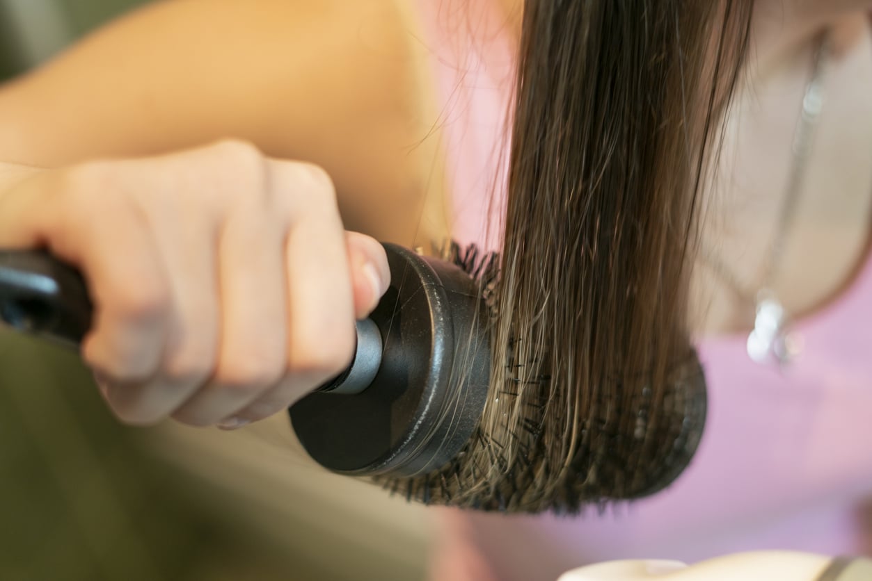 Blow dry hair with a round brush for more volume for medium-length hair