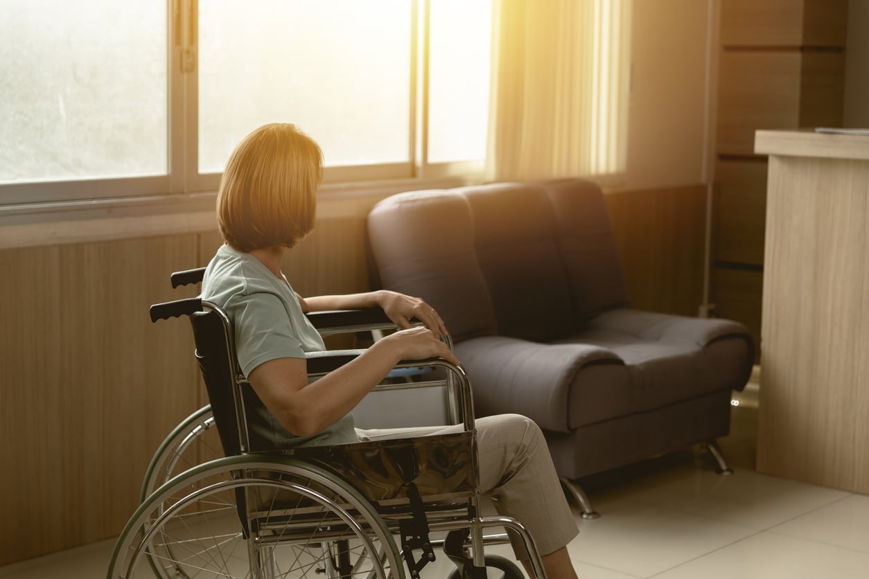 Woman sitting alone in a wheelchair, loneliness, senior living