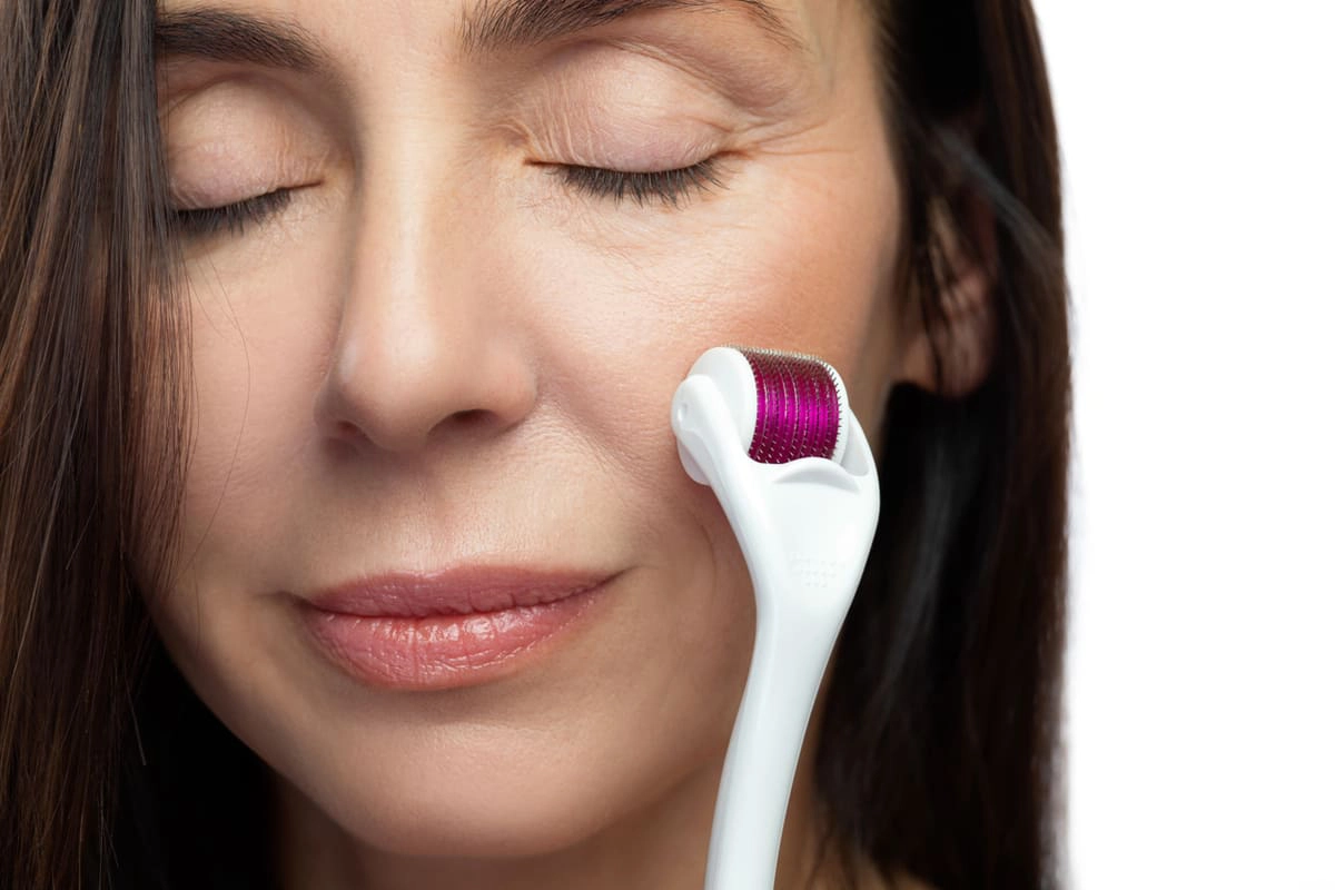 Woman microneedling her face