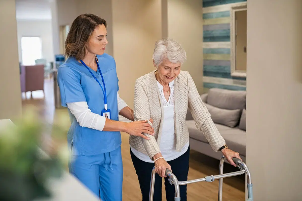 Woman using a walker with a nures