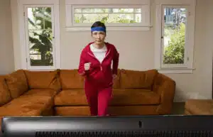 Woman exercising in front of television; Best Amazon Prime Workouts