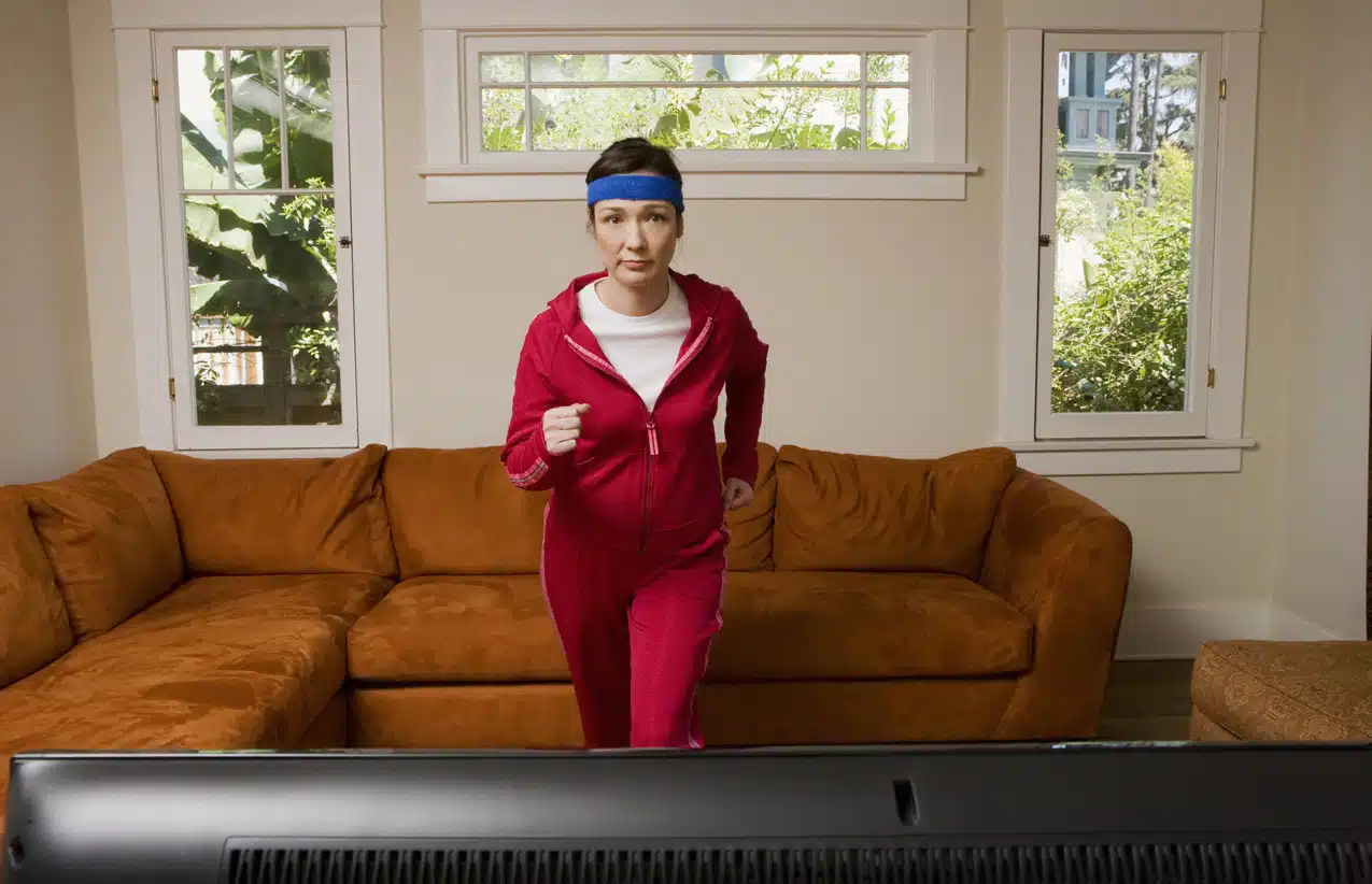 Woman exercising in front of television; Best Amazon Prime Workouts