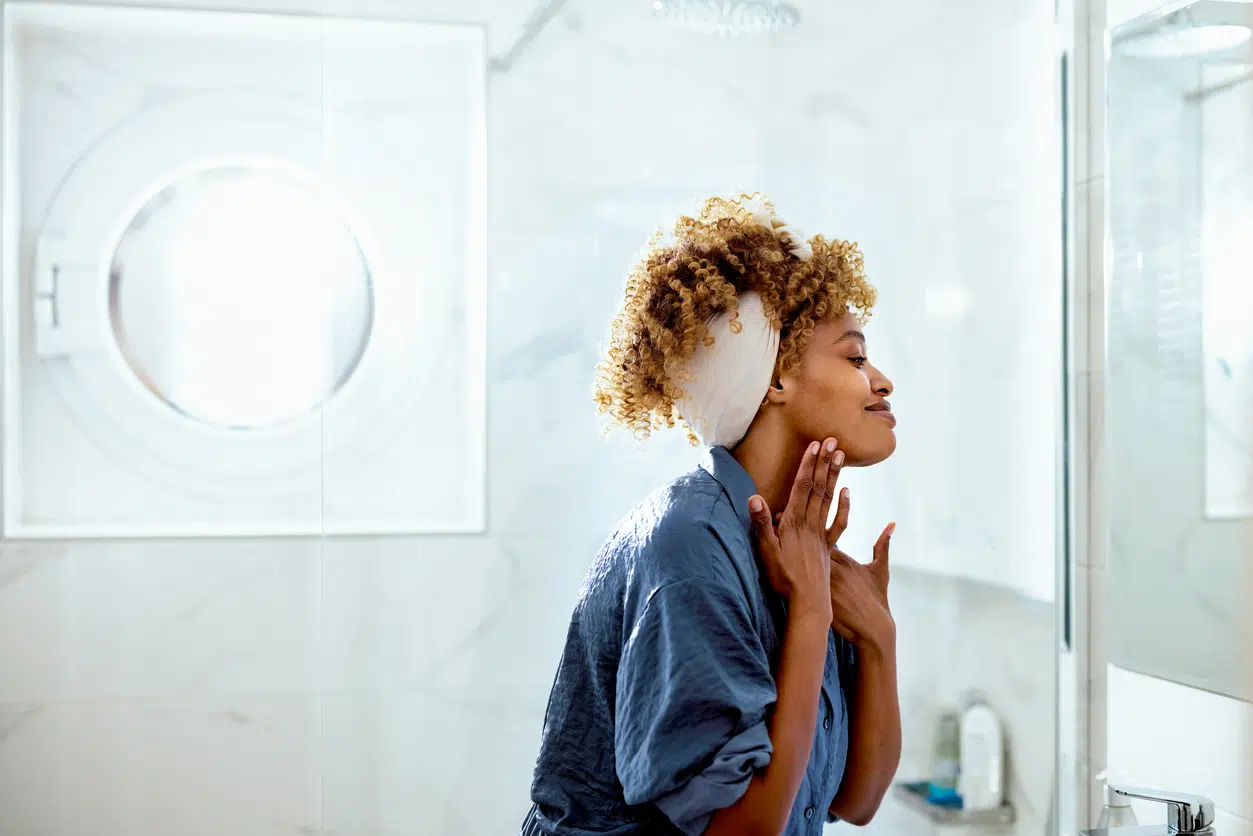 Woman looking at her face in the mirror
