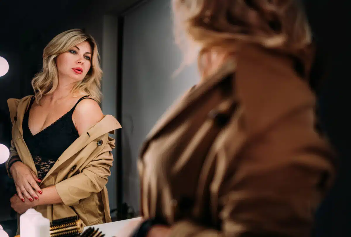 Woman looking in the mirror; confidence