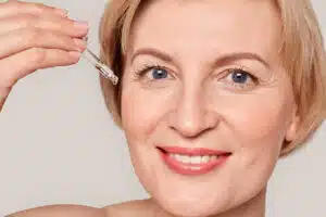 CBD facial; Woman putting oil on her face
