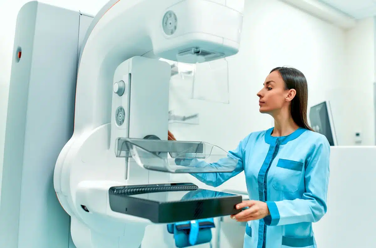 Technician working on a mammogram machine