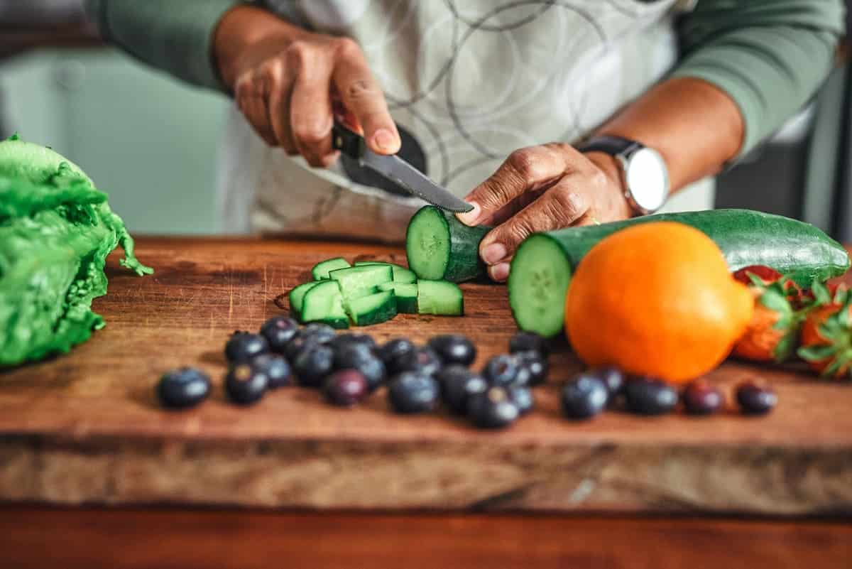Woman cutting fresh fruit and veggie