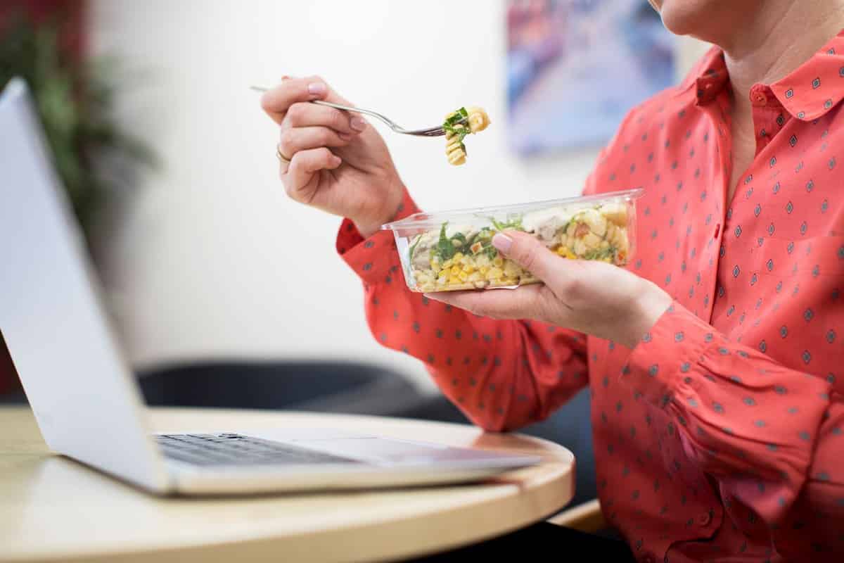 Woman eating a healthy meal at her desk