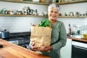 Woman with grocery bag of healthy foods that prevent breast cancer