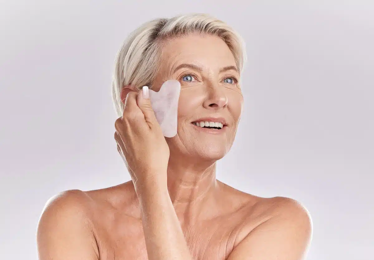 woman doing gua sha on face