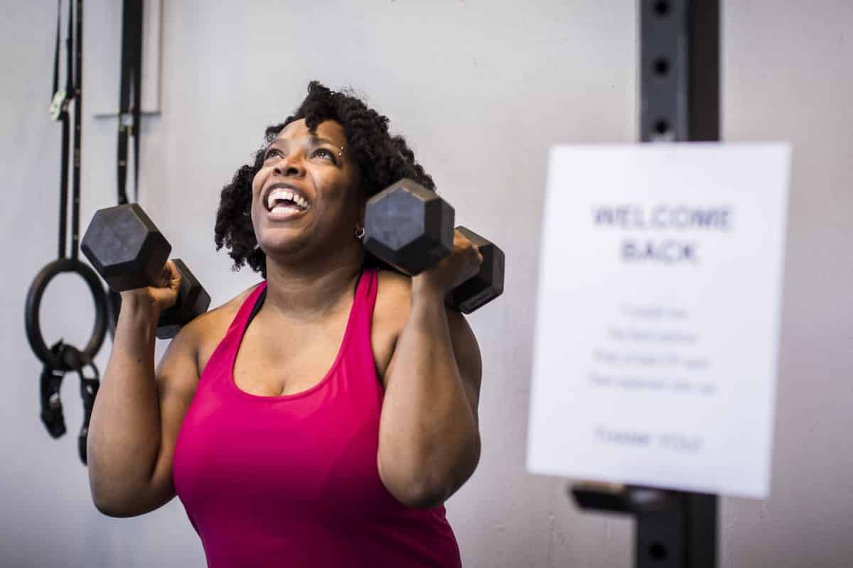 woman lifting weights smiling