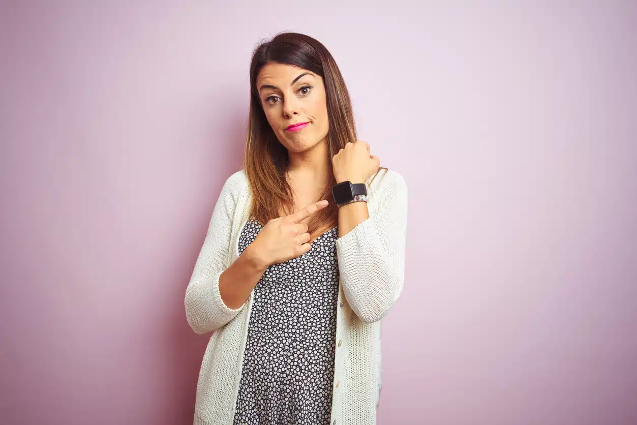 Woman looking at her watch waiting impatiently