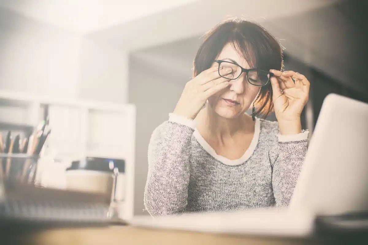 woman rubbing her tired eyes
