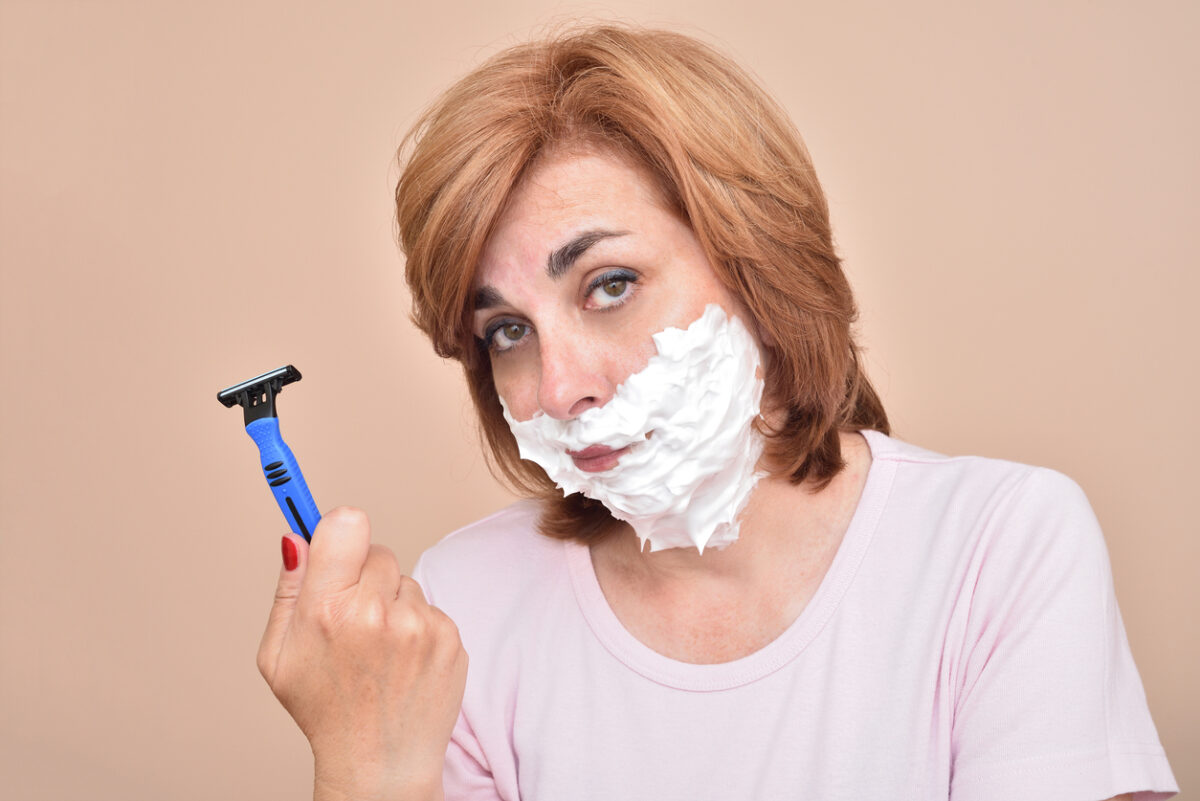 Woman shaving her face