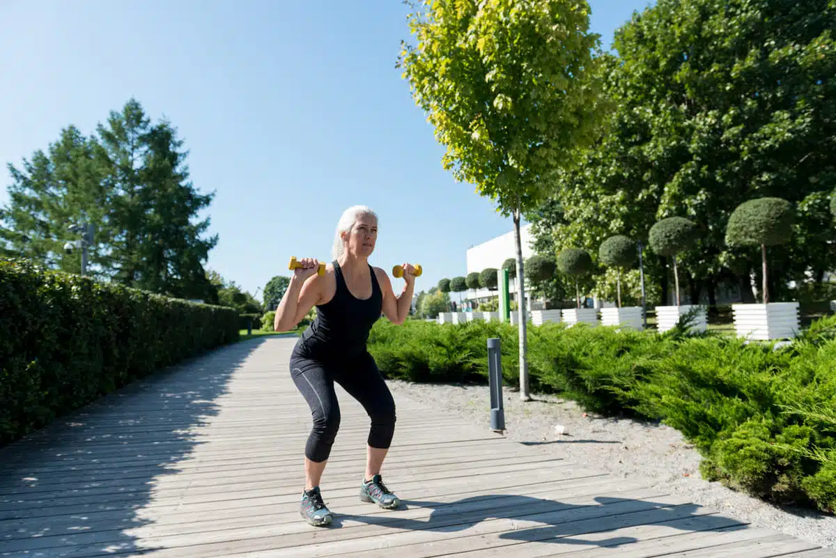 Dumbbell squat woman outdoors