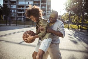 Grandfather playing basketball with grandson