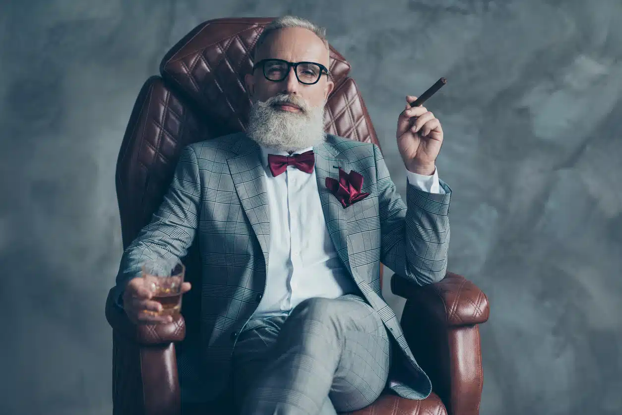 Arrogant guy with glasses sitting in a chair with a scotch and cigar
