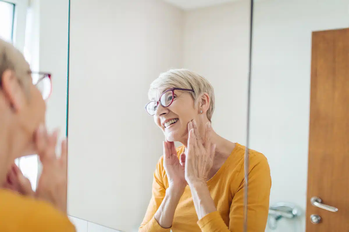 woman looking at her face in the mirror