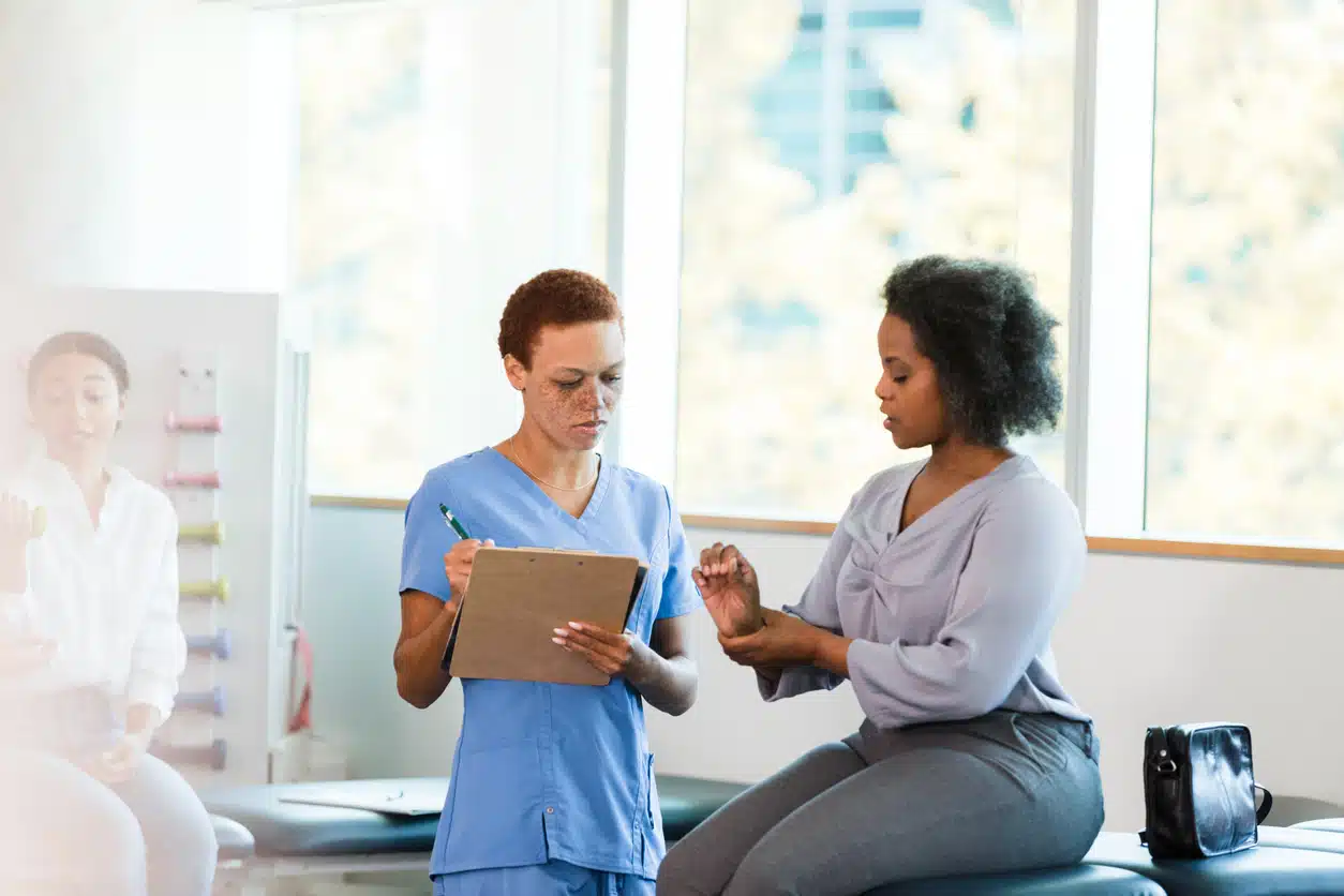 Woman taking to doctor about wrist and joint pain