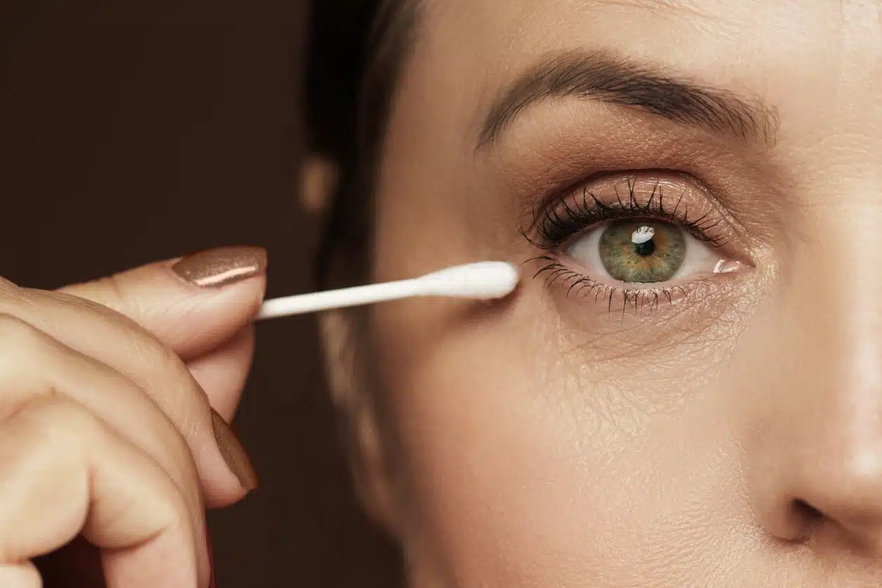 Woman putting on eye makeup, Q-tip, Close up of eyes