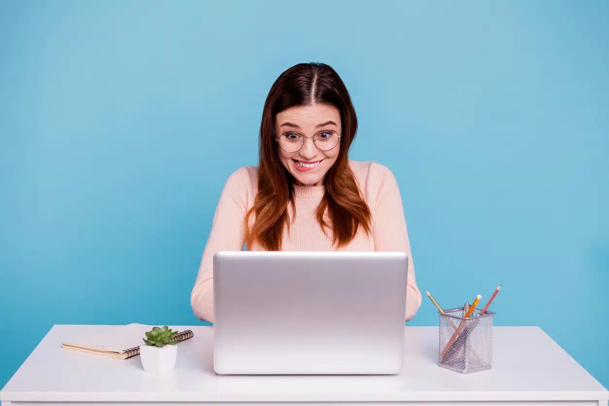 Woman excited typing on her laptop