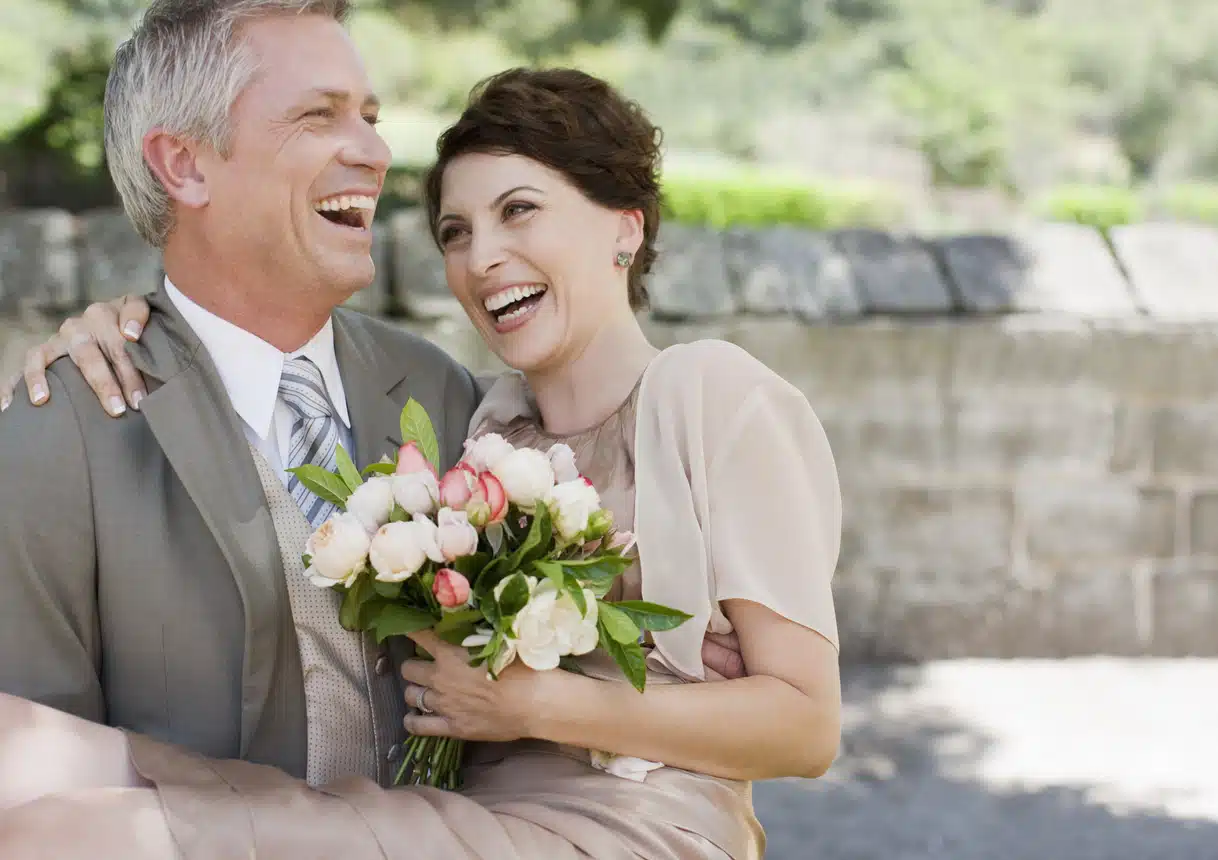 Mature groom carrying bride