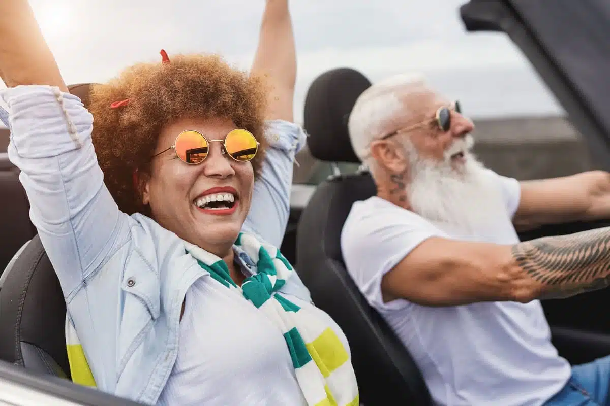 old people riding in a convertible