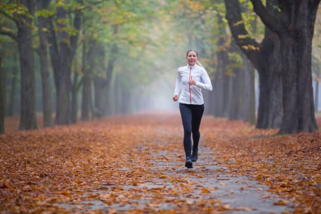 Woman running in the woods, myths of a healthy lifestyle