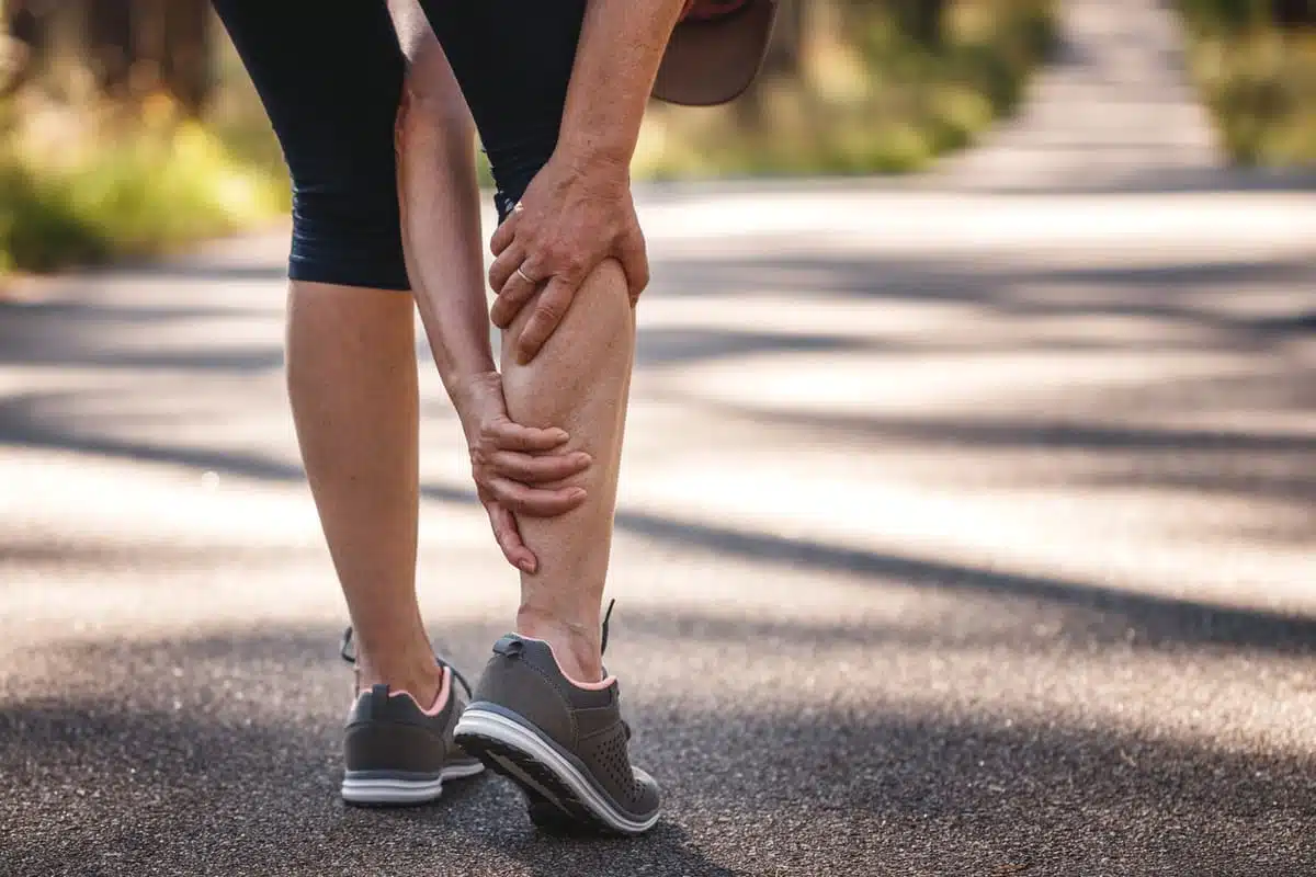 tight tendon, woman rubbing her calf