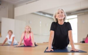 woman doing yoga downward dog club pilates FEATURE