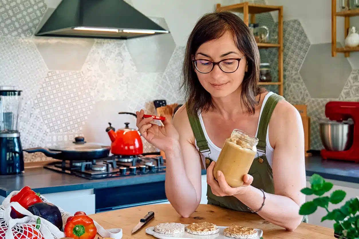 Woman eating peanut butter; Nut Butters FEATURE