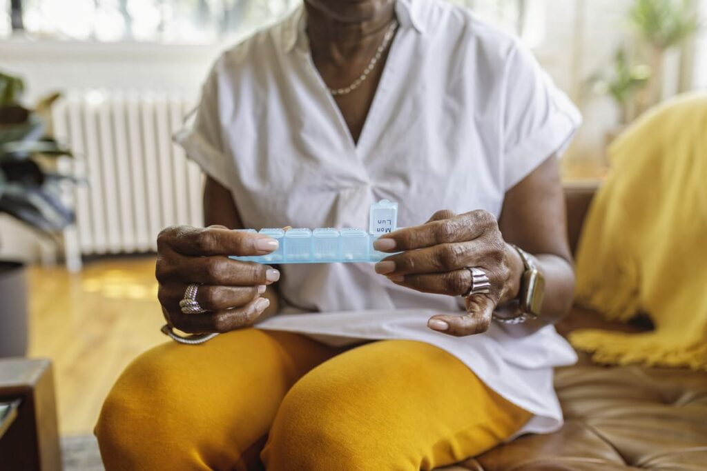 Woman taking medication from a pill box