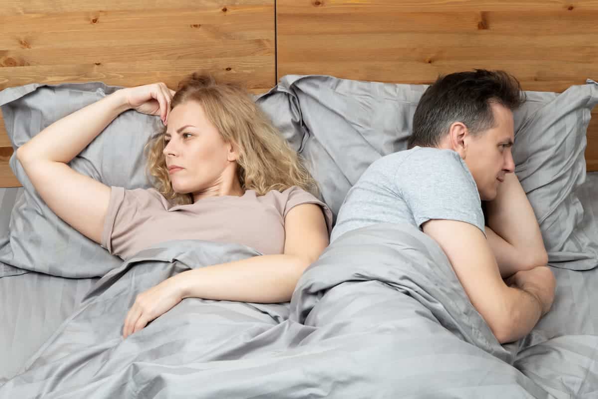 couple in bed not talking, fighting