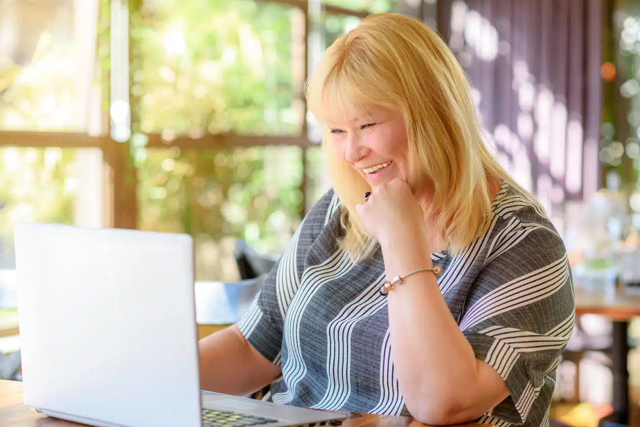 Portrait of woman sitting in cafe and using a computer. 