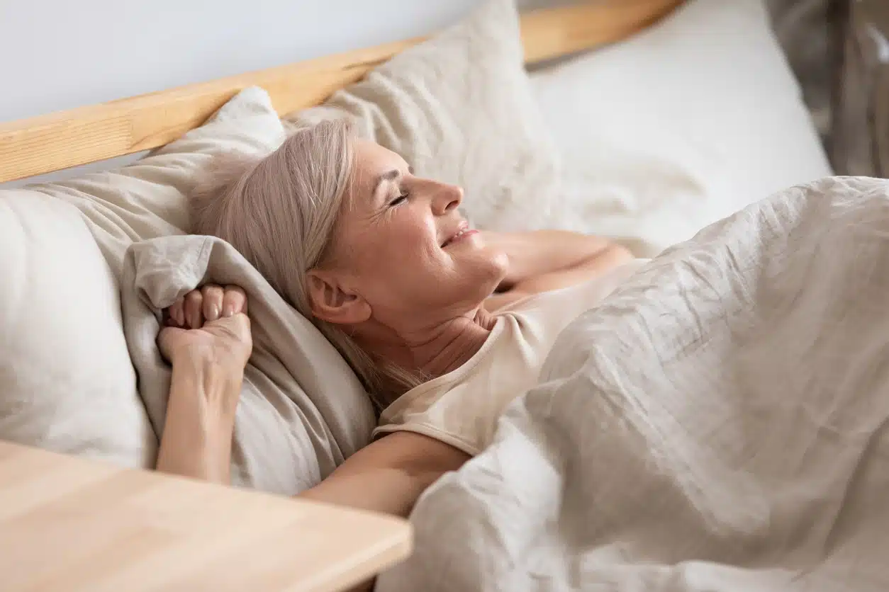 middle-aged woman lying in bed enjoy early morning