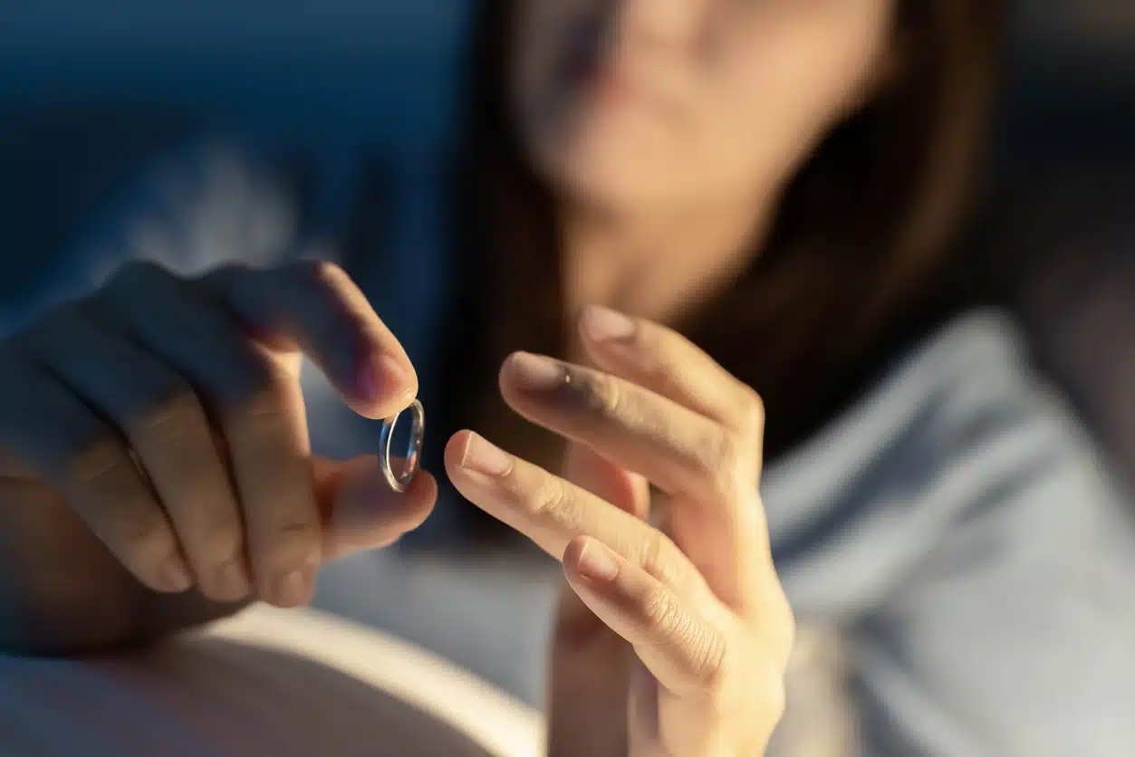 depressed woman holding wedding ring