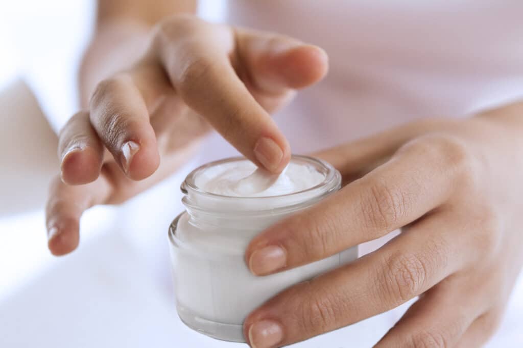 woman's hand touching on the cream for applying