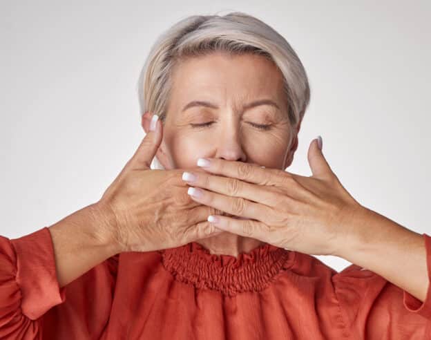 Mouth ulcers, mouth pain, woman covering her mouth
