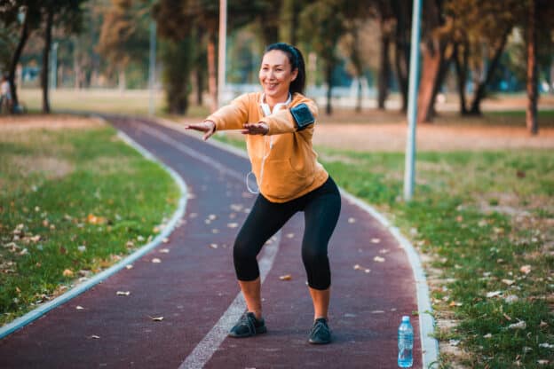 Woman doing squats on a walking path