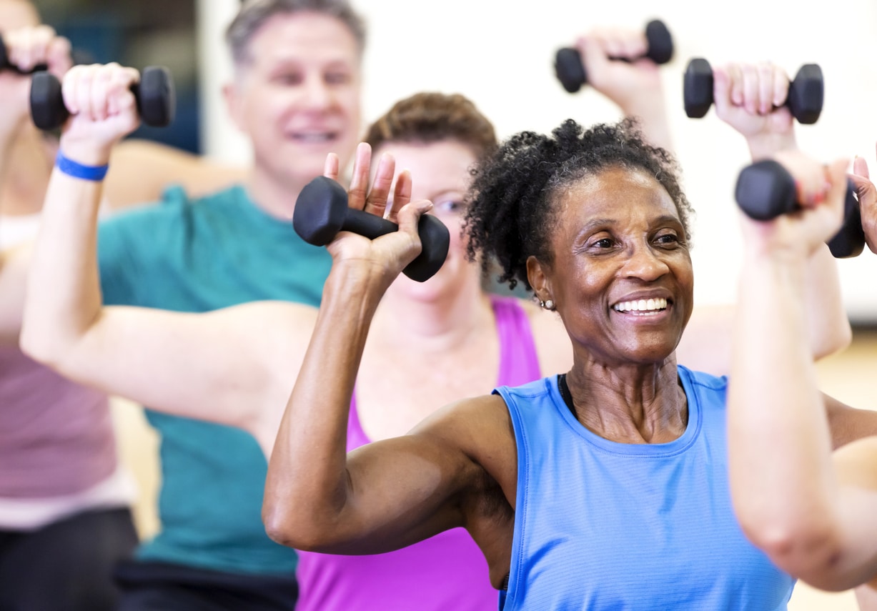 Woman with dumbbells working out in exercise class
