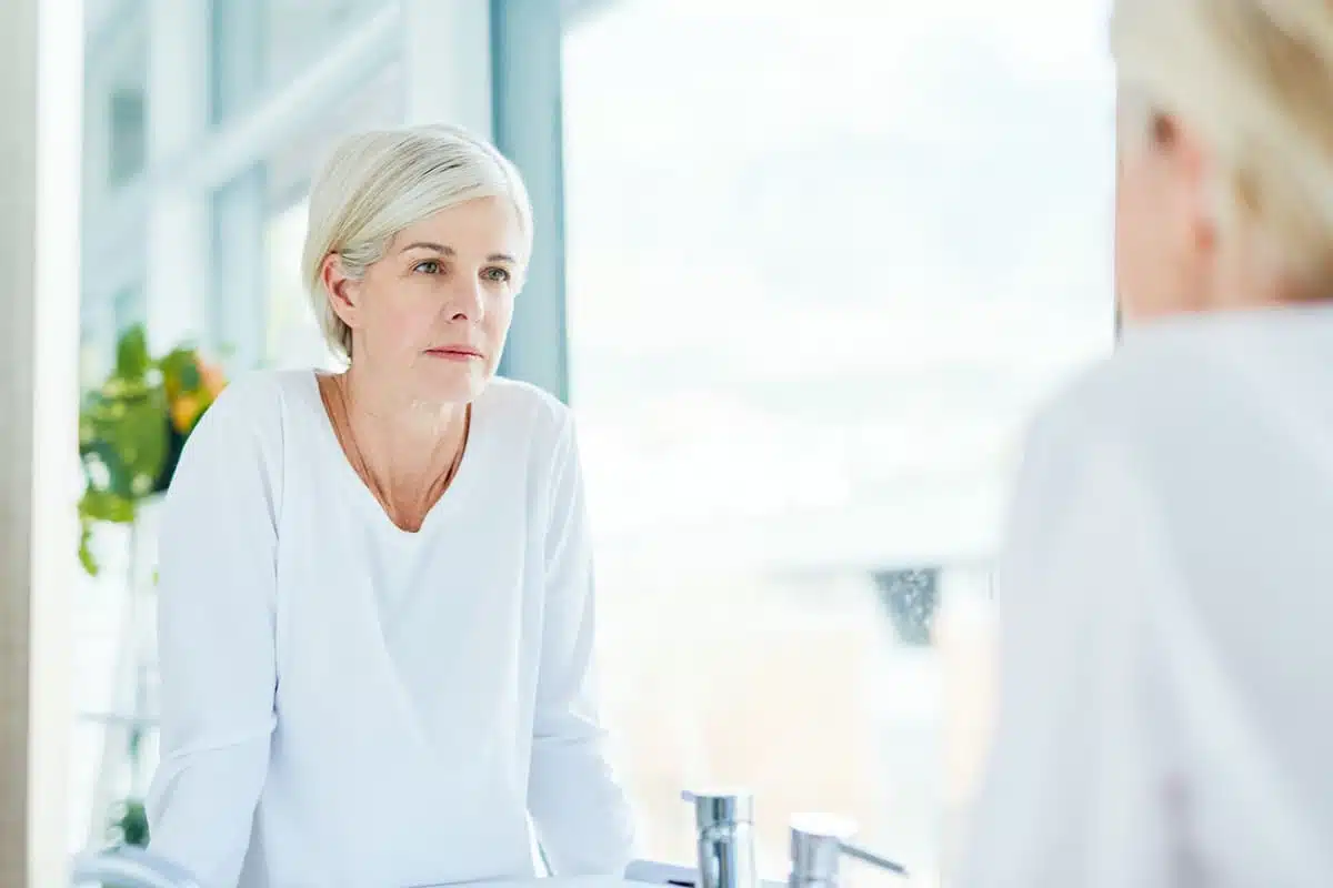 woman looking in the mirror self-compassion.