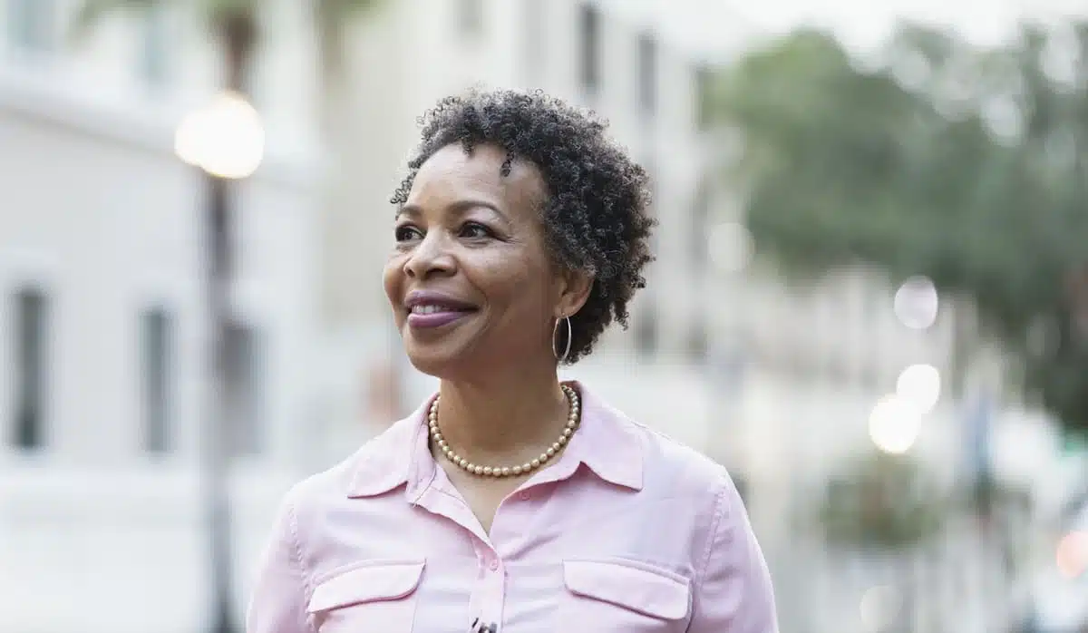 woman smiling as she walks down the street