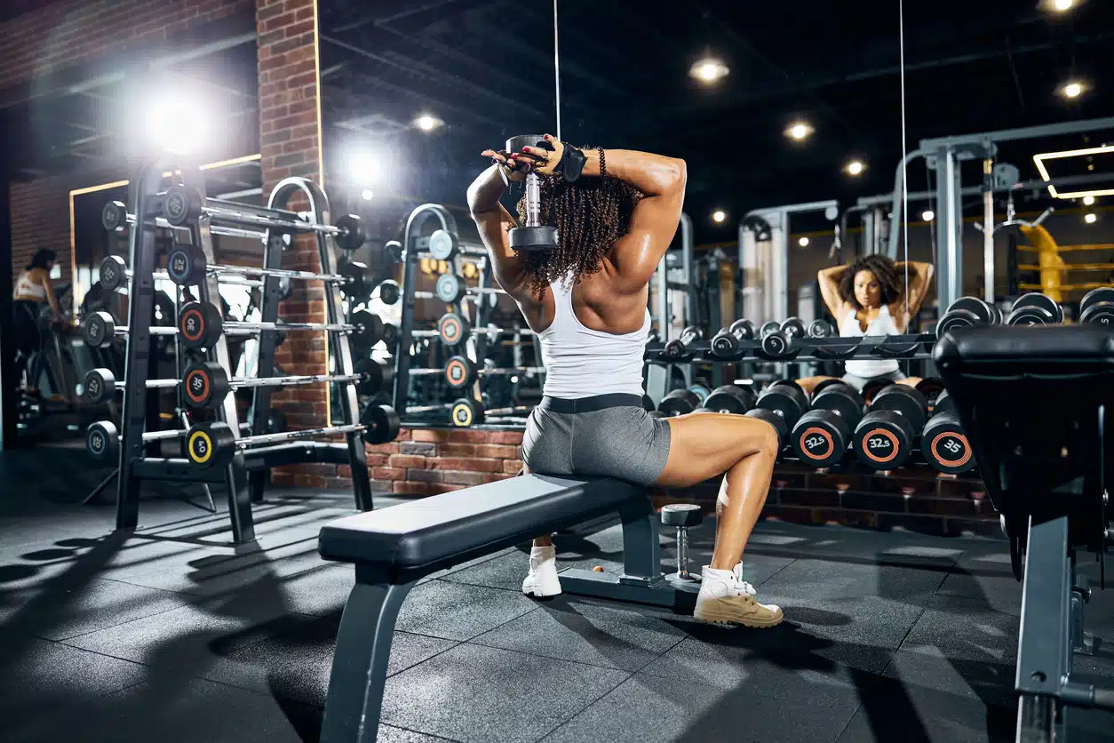 Woman doing overhead triceps extension; arm exercises; dumbbells