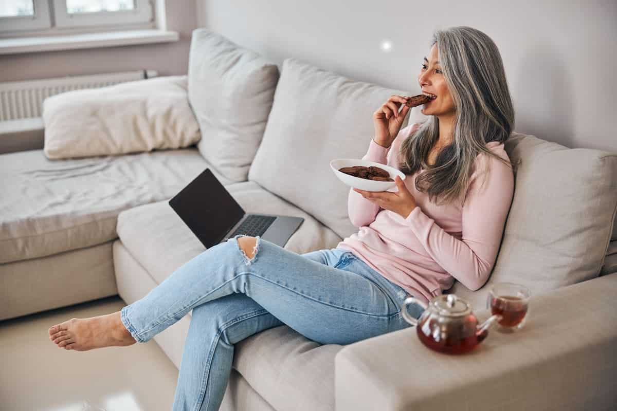 Woman eating cookies and tea