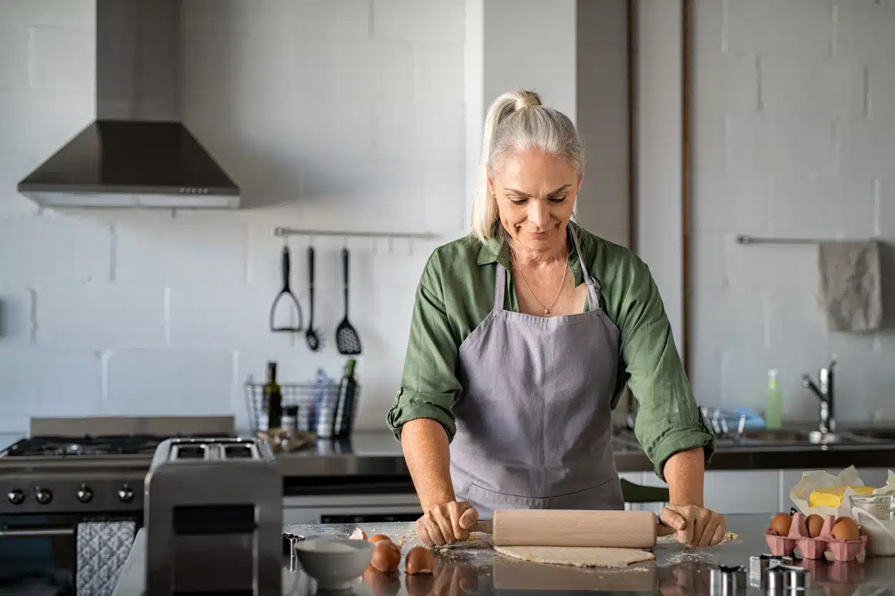 Senior woman rolling cookie dough at home